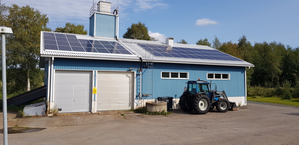 Kuva rakennuksesta ja sen katolla olevista aurinkokennoista.